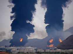 plumes of smoke and fire rise after debris from an intercepted iranian drone struck an oil facility according to authorities in fujairah united arab emirates saturday march 14 2026