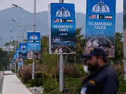 sicherheitspersonal steht neben schildern zu den verhandlungen zwischen den usa und dem iran vor einem medienzentrum