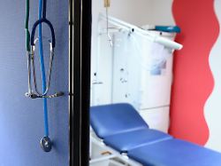 stethoskope haengen im behandlungszimmer einer hausarztpraxis ueber einer trennwand