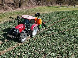 themenfoto landwirtschaft duengen pestizide ein landwirt faehrt mit seinenm traktor ueber ein gruenes feld und duengt mit pestiziden