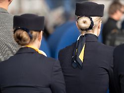 zwei flugbegleiterinnen der lufthansa in uniform von hinten