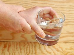in a woman with parkinson s shaking hands so much that she spills a glass of water
