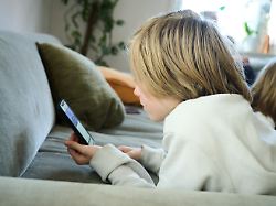 archiv 21 04 2025 bayern roth ein junge liegt auf einem sofa und blickt auf sein smartphone gestellte szene