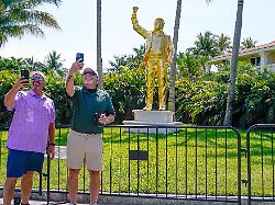 apr 30 2026 miami florida usa fans pose for a photo in front of a statue of president donald trump during the first round of the cadillac championship golf tournament