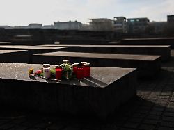 blumen und kerzen wurden auf einer stehle am denkmal fuer die ermordeten juden europas niedergelegt