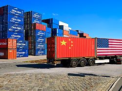 container mit usa und china fahne auf einem lkw im hintergrund gestapelte container zollstreit zwischen usa und china fotomontage