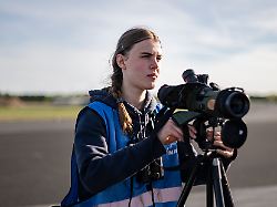 cora koeberle mitglied des young birders club beobachtet auf dem flugfeld des stillgelegten flughafen tegel mit einem fernglas voegel