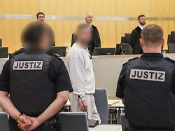 der angeklagte m steht zwischen justizangestellten im gerichtssaal der 49 jaehrige mann aus der rechten szene in dortmund soll zu attentaten auf bekannte politiker aufgerufen haben