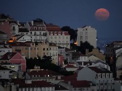 der vollmond geht hinter dem stadtteil castelo auf