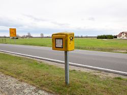 ein verwitterter briefkasten der deutschen post am rand eines dorfes im spreewald