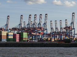 frachtcontainer und containerbruecken vor blauem himmel am containerterminal burchardkai im hafen von hamburg deutschland