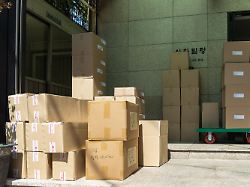 gestapelte pakete stehen vor einem gebaeude in seoul zur auslieferung bereit sendungen aus dem onlinehandel warten auf verteilung und zeigen die bedeutung von e commerce und logistik im alltag
