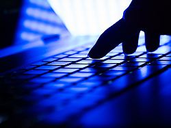 hand auf einer laptop tastatur in einem dunklen raum