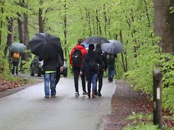 spaziergaenger laufen auf einem weg im thueringer muehltal bei regnerischem wetter und unter coronabedingungen waren nur wenige feiertagsausfluegler an christi himmelfahrt unterwegs