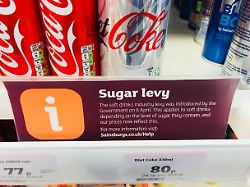 sugar levy tax sign showing the governments new sugar tax levy in sainsburya a a s supermarket knutsford cheshire uk