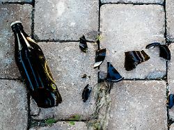 zerbrochene bierflasche auf pflastersteinen zurueckgelassen