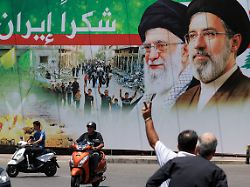 a man flashes a victory sign as he rides a motorcycle past a banner that reads thank you iran following a deal between the u s and iran in the southern suburbs of beirut lebanon june 15 2026