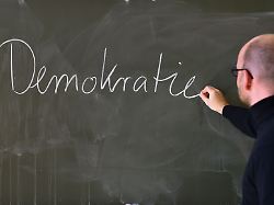 andreas steiner schulleiter der fichtenberg oberschule im berliner steglitz schreibt an der tafel das wort demokratie