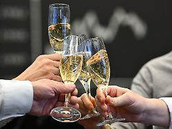 boersenhaendler stossen am letzten handelstag des jahres im handelssaal der wertpapierboerse vor der tafel mit der dax kurve mit sekt an