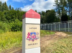 ein grenzpfeiler mit der aufschrift republik lettland steht an der lettischen grenze zu russland