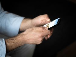 ein mann tippt auf einem smartphone 1