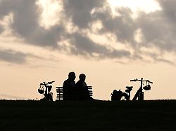 ein rentnerpaar macht eine pause von ihrer e bike tour und sitztzum sonnenuntergan auf einer parkbank neuharlingersiel 23 05 2026 1