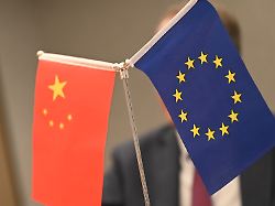 eine chinesische und eine europaeische fahne stehen auf einem tisch