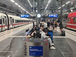 fahrgaeste sind auf einem bahngleis im berliner hauptbahnhof unterwegs waehrend zuege auf den gleisen stehen der verkehr der deutschen bahn ist wegen einer funkstoerung bundesweit eingestellt
