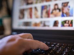hand of man searching pornography on laptop at home model released symbolfoto jatf01257