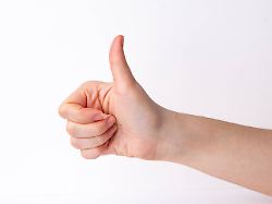 hand zeigt daumen hoch geste vor einem einfarbigen hintergrund hand shows thumbs vertical gesture before a monochrome background 1103504257