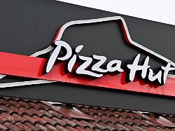 kudamatsu japan april 14 the illuminated corporate logo and iconic red roof signage of a pizza hut restaurant are mounted against a dark facade in kudamatsu yamaguchi prefecture japan on april 14 2026