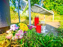 kerzen und blumen sind in der naehe eines bachlaufs abgelegt wo die leiche eines babys entdeckt wurde mit dutzenden suchhunden und hubschraubern suchte die polizei seit dem vortag nach einem saeugling