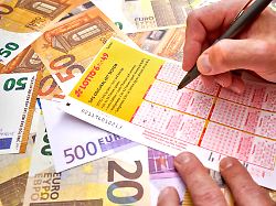 lotto 6 aus 49 lottoschein bzw spielschein sechs kaestchen werden von einer hand angekreuzt person gibt ihren tipp ab um moeglichst viele richtige zu gewinnen
