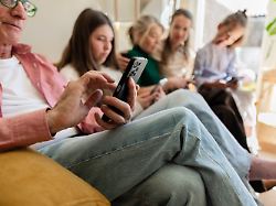multi generational family using smartphones together in living room model released symbolfoto property released jccmf15256