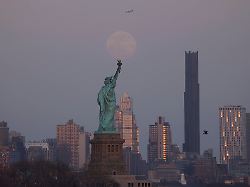 news bilder des tages a full blood worm moon rises behind the statue of liberty and the brooklyn tower in new york city on thursday march 13 2025