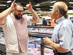 produktion 10 06 2026 bayern nuernberg metzger yevgeniy klibanov l lernt gebaerdensprache um sich an der theke im supermarkt mit gehoerlosen kunden wie stammkunde hedi doudeche r zu unterhalten