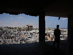palaestinenser inspizieren die truemmer eines gebaeudes das bei einem israelischen luftangriff im suedlichen gazastreifen zerstoert wurde