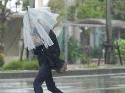 people walk against strong winds and rain as typhoon mekkhala no 7 approaches naha city okinawa prefecture japan on june 26 2026 1