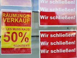 raeumungsverkauf geschaeftsaufgabe wir schliessen alles muss raus um 50 reduzierte ware plakate an der schaufensterscheibe