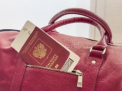 red passport and boarding pass are sticking out of the pocket of the bag red russian passport with airline ticket on touristic red bag close up tourism and travel concept