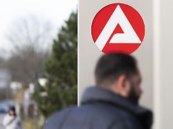 stele mit dem zeichen logo der agentur fuer arbeit vor dem gebaeude der agentur fuer arbeit unscharfe personen auf dem weg zur agentur koeln nordrhein westfalen deutschland