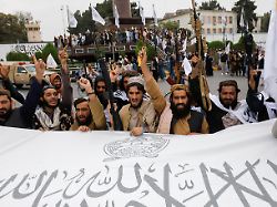 taliban fighters hold an islamic emirate of afghanistan flag on the first anniversary of the fall of kabul on a street in kabul afghanistan august 15 2022