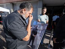 weinend wartet erdal calar vater des getoeteten zugbegleiters serkan calar mit einem bild seines sohnes in der hand auf einlass in das landgericht
