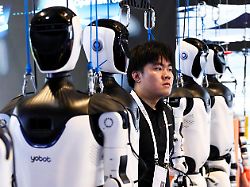 a staff member stands among humanoid robots on display at the efort booth during the world artificial intelligence conference waic in shanghai china july 17 2026
