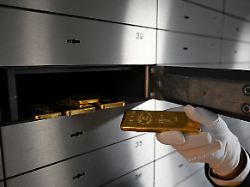 an employee handles a gold bar as bars of various values are stored in a safe deposit room in munich germany january 28 2026