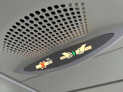 anschnallzeichen in einem passagier flugzeug economy klasse anschanllen rauchverbot rauchen verboten anschnallen zeichen anzeige