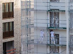 arbeiter verputzen ein haus mit eigentumswohnungen die zahl der baugenehmigungen ist leicht angestiegen die zahl der neuen wohnungen in nordrhein westfalen ist auf dem niedrigsten stand seit 2011