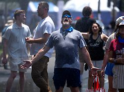attendees cool off in a misting station outside the great american state fair after the event was closed for the afternoon due to extreme heat on the national mall friday july 3 2026 in washington