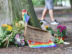 berlin deutschland auto faehrt bei csd in menschenmenge am tatort haben menschen blumen niedergelegt auf einem schild steht wir lassen uns nicht spalten