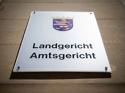 blick auf ein schild mit dem landeswappen von hessen und der aufschrift landgericht amtsgericht